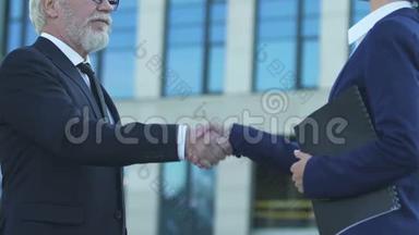 老商人与销售经理握手，创业成功